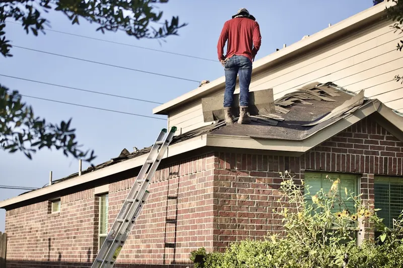 Professional roofer working on a residential roof in Jamison